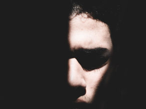 a man with half his face lit, and the other half in darkness
