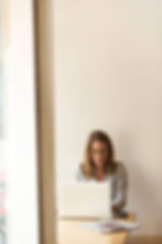 a health coach working on her LinkedIn profile in a clean and modern room on a wooden table