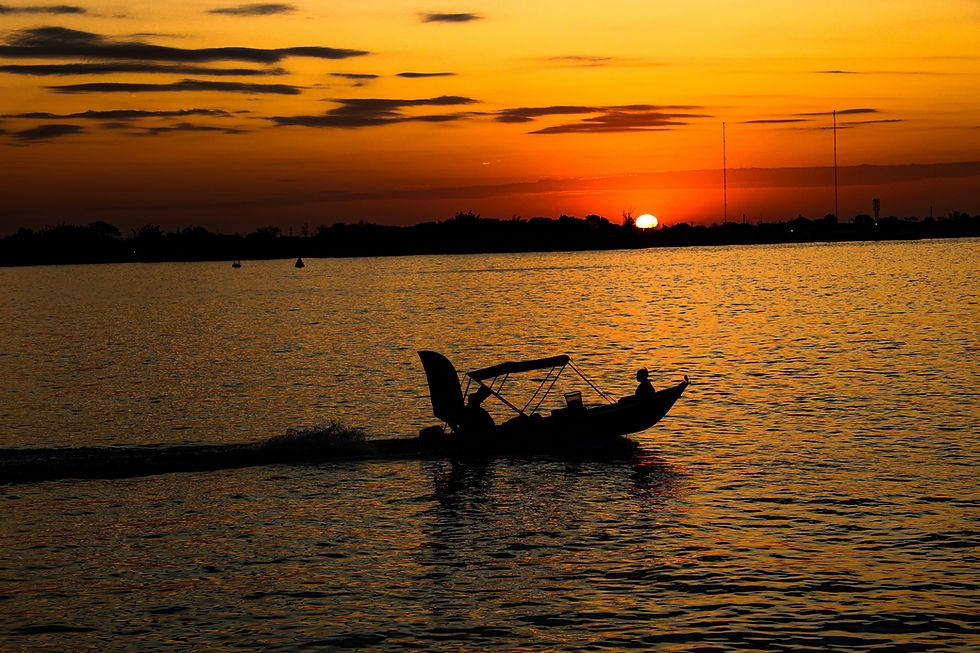 Barco ao por do sol em lagoa.