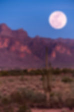 The full moon in the desert in the evening sky.