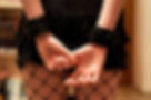 Woman wearing leather handcuffs.