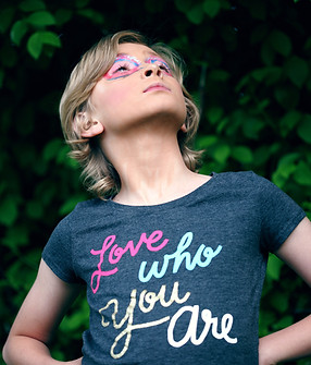 Confident young boy wearing T-shirt with slogan "love who you are"
