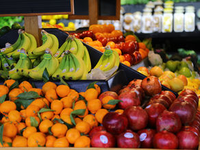 a selection of bright fruit is displayed on the shelves of a store.