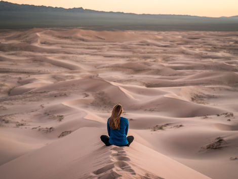 a woman sitting in the desert, visualizing