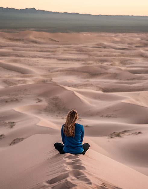 woman sand on hard compacted sand, back to the camera