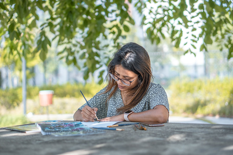 a girl standing under a tree and writing on a notbook