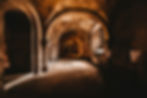 Stone corridor with arched ceilings and dim lighting