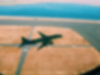 plane landing with body of water in the background