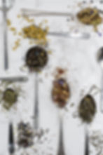 spoons filled with herbs lying on a marble counter