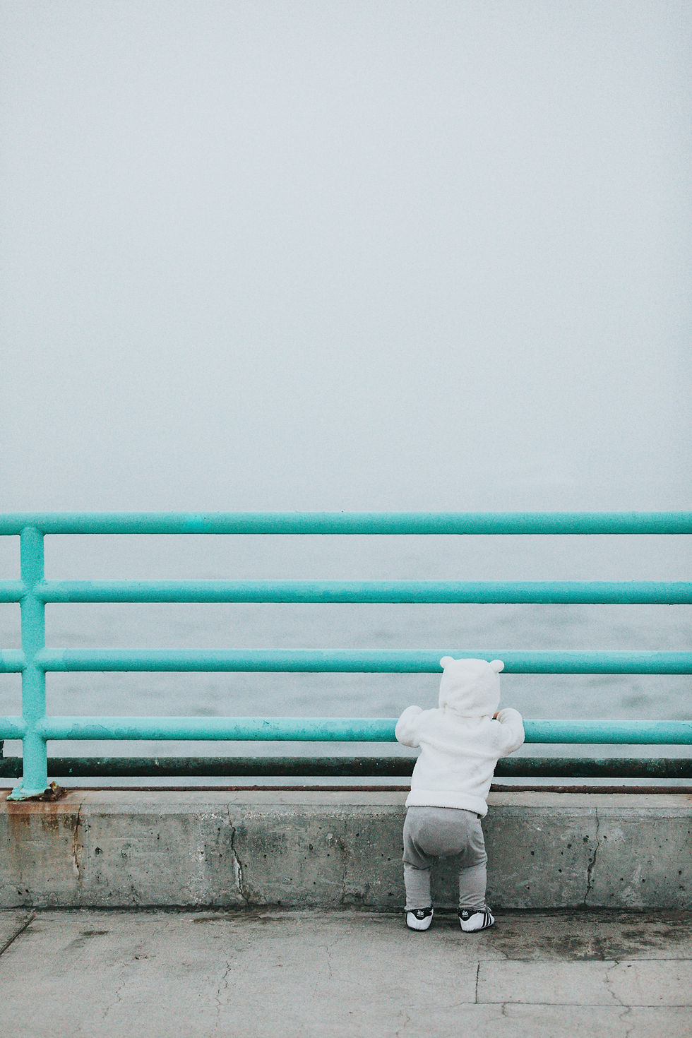 A cute baby stares at a wall.