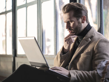 Un cadre réfléchit à sa reconversion professionnelle à 40-50 ans devant son ordinateur