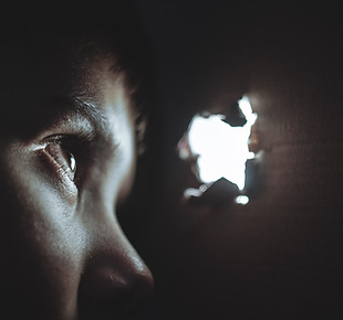 person looking through hole at another without permission