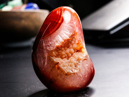 une cornaline posé sur le bureau d'une personne passionnée de lithothérapie