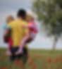 Man holding his two children, walking in a field. Melancholic ambiance.
