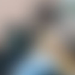 woman holding a coffee cup while her dog lies across her lap