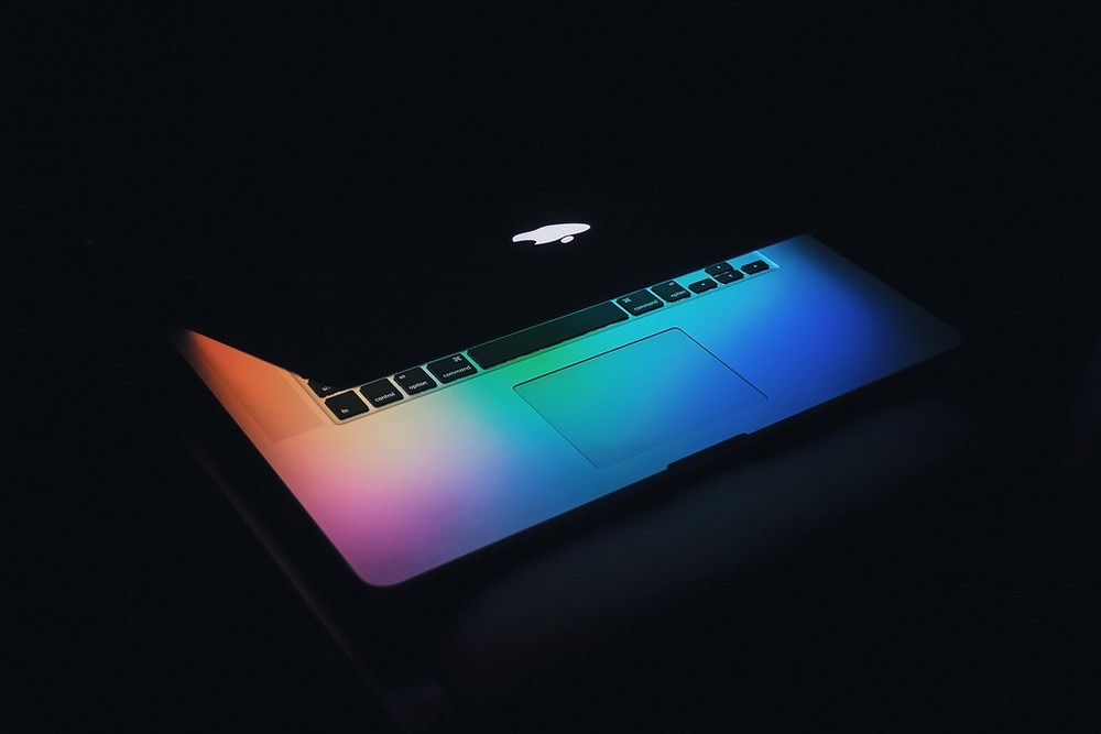 Apple macbook with screen glowing in dark