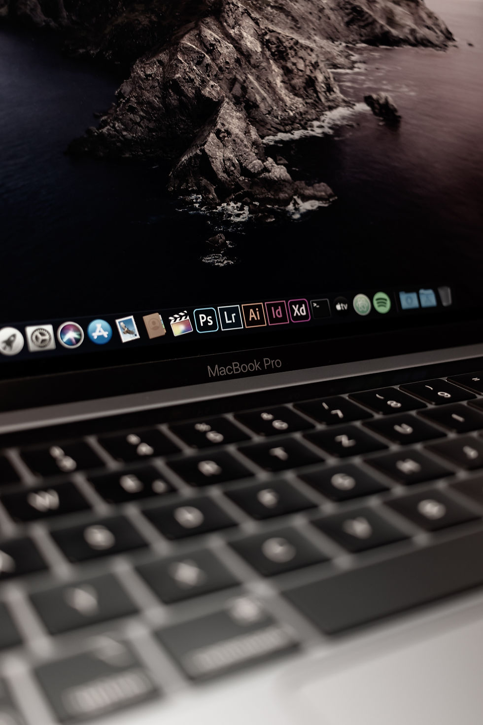 Apple Macbook Pro marka dizüstü bilgisayarın ekranında Adobe ürünleri görünüyor.