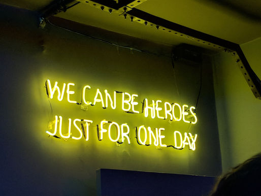 neon sign that says "we can be heroes just for one day"