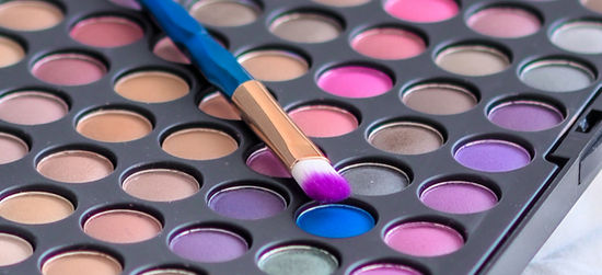 Eyeshadow palette with brush dipped in blue