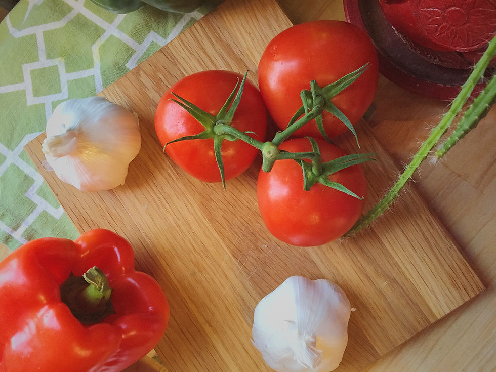 Garlic and tomatoes on top of wooden cutting board