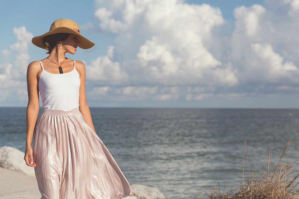 The sunhat, wide-brimmed and stylish, serves to protect her hair from the sun's rays while adding an elegant touch to her overall look.