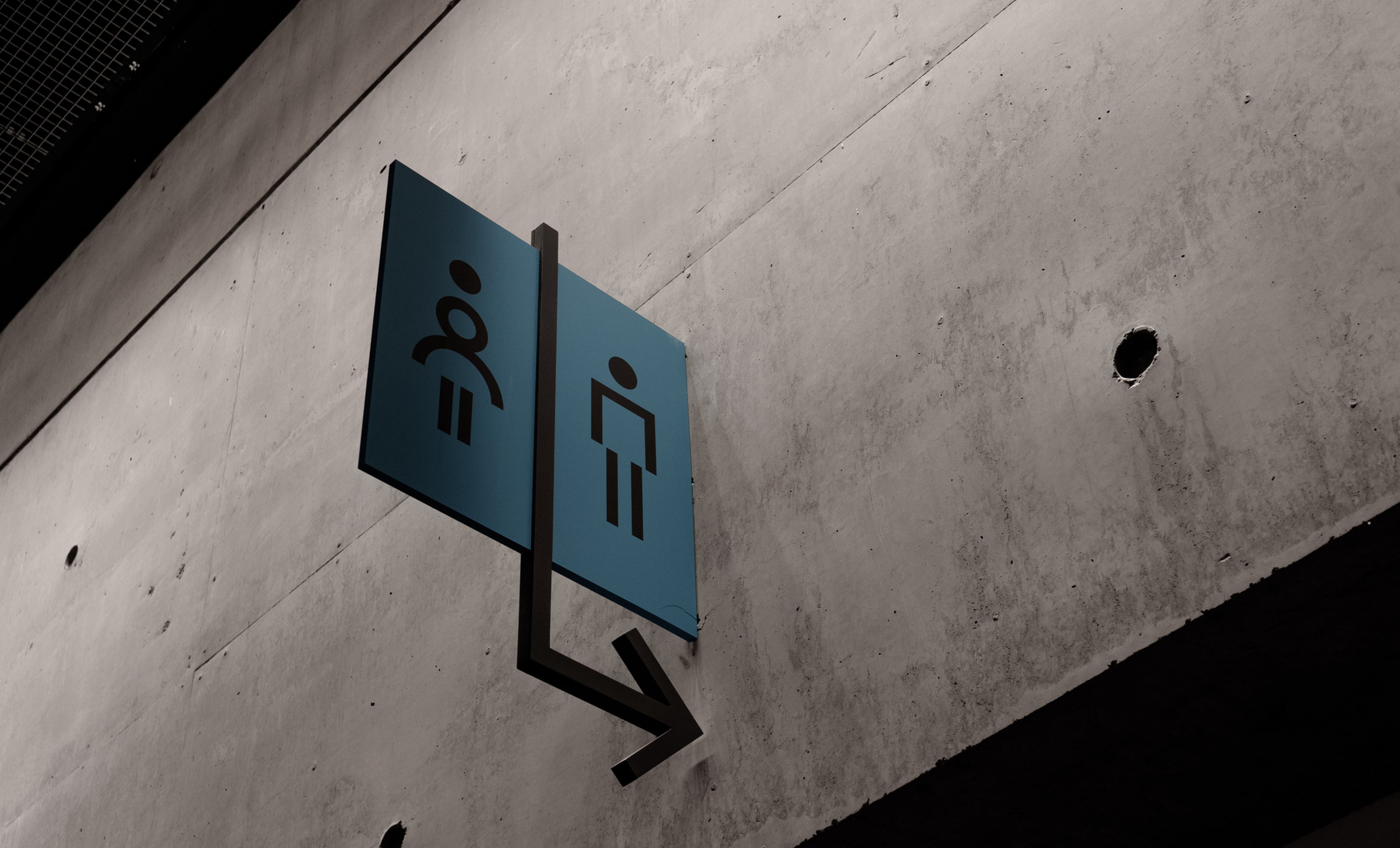 Restroom sign against concrete wall