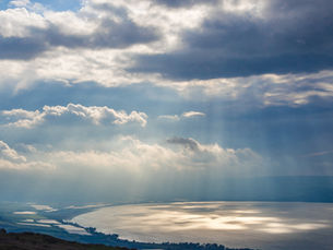 Dramatic sunbeams breaking through clouds over the Sea of Galilee (Lake Kinneret) during a private tour of Northern Israel.