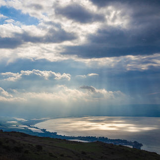 Dramatic aerial view of sunbeams reflecting off the Sea of Galilee from a mountain lookout in Northern Israel.