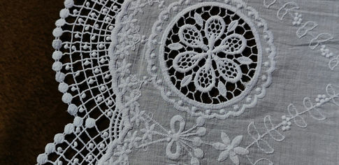 Artisane jurassienne réalisant une dentelle fine à la main dans un atelier lumineux de Poligny, ambiance paisible et savoir-faire délicat.