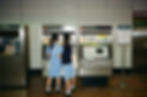 Two students in uniforms using a ticket vending machine in a metro station, demonstrating everyday ICT interactions that need to be accessible to everyone.