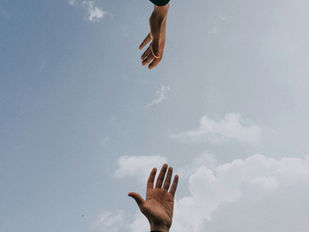 Two outstretched hands reaching together for support.