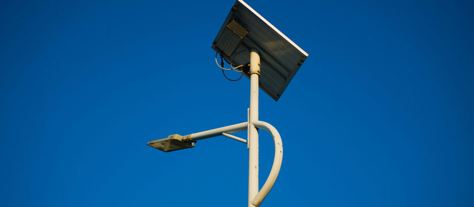 A tall security light pole with solar panel representing sustainable security technology.