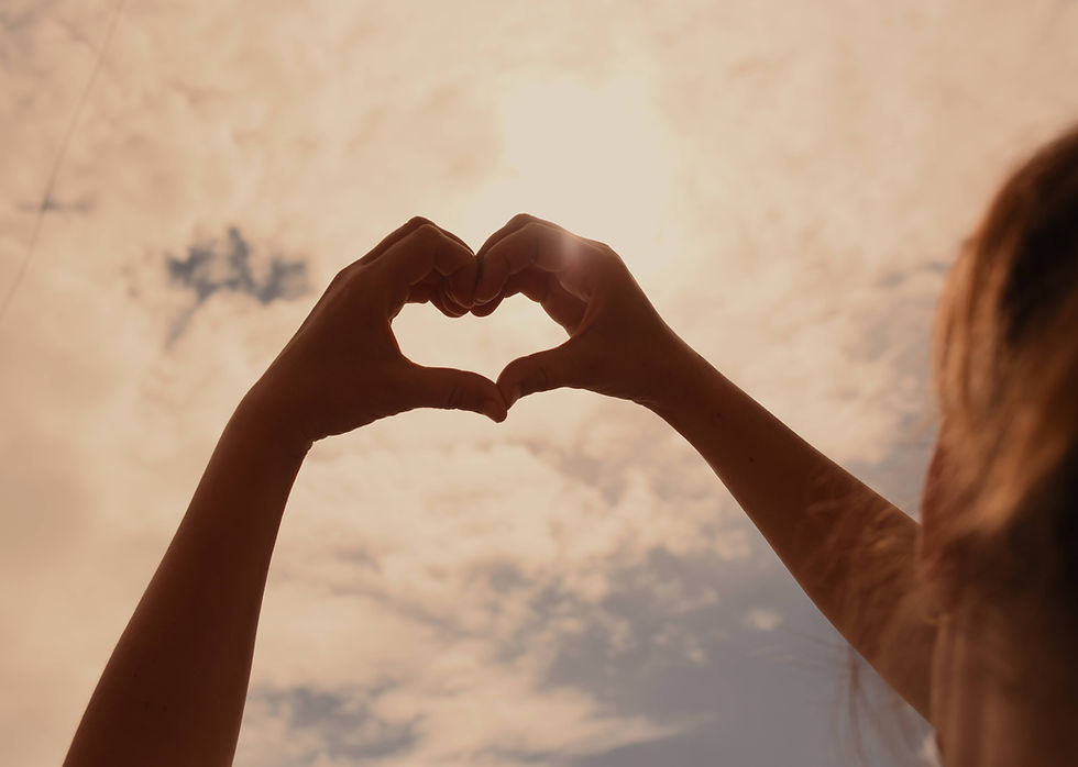 Woman holding heart hands up to the sky