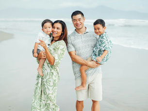 A joyful family strolls along the beach, enjoying quality time together on a tranquil day.