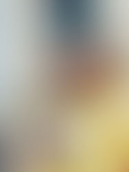 Nuori musta nainen selailee älypuhelinta, kertakäyttöinen kahvimuki kädessään tiilisen kaupunkirakennuksen edessä