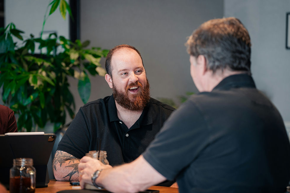 A serious injury lawyer from West Coast Trial Lawyers discusses case details with a client, both focused on documents spread out on the desk.