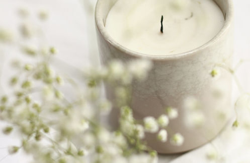 photo of candle in grey pot with flowers