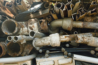 Stack of discarded brass fittings, copper pipes, and plumbing scrap metal