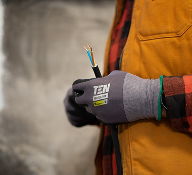 Upclose of an electrician with a glove on holding wires.