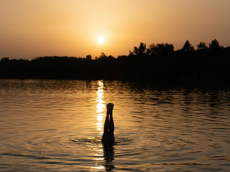 Handstående i en sjö i solnedgången