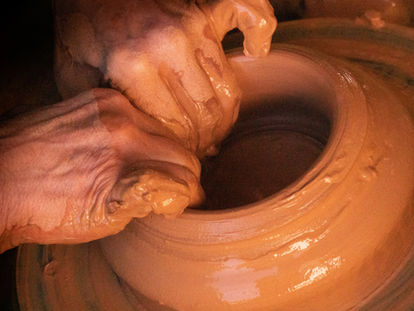 Um homem moldando um vaso de barro