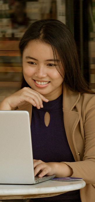 A designer smiles while working on her laptop.