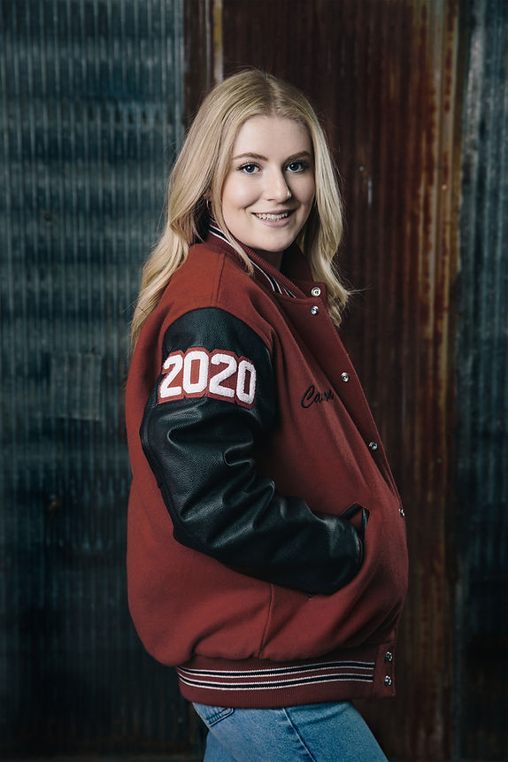 Senior class girl wearing a school spirit letterman jacket with her graduation year embroidered