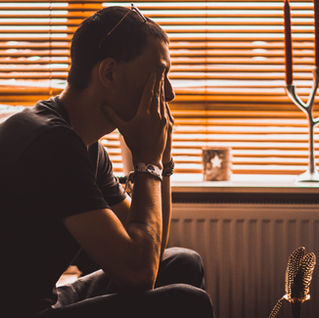 Man sitting quietly and looking overwhelmed, representing why men say I don’t know during hard conversations.