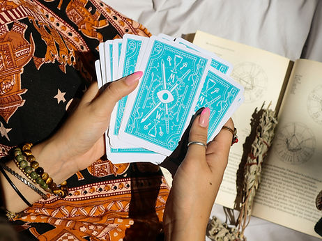 Kartendeck in den Händen einer Kartenlegerin während einer Tarot Ausbildung erklärt sie wie man Karten legt