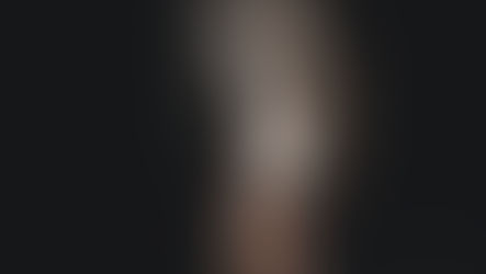 woman with a white mask over her entire face with her finger over her lips "sushing"