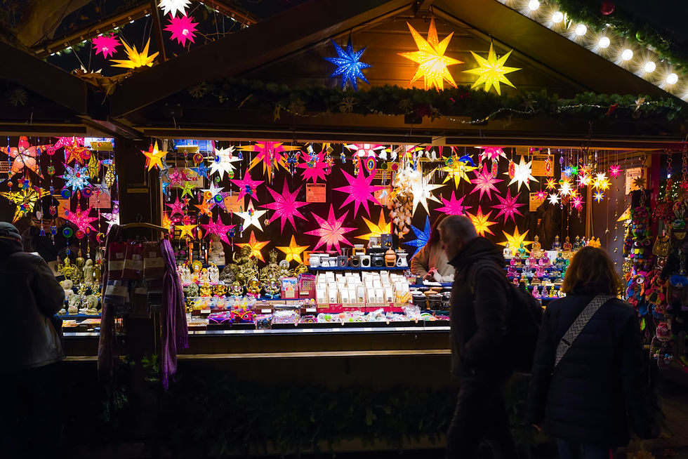 Wide-angle view of a snowy Christmas market square in an Erzgebirge town with wooden stalls and warm lights.