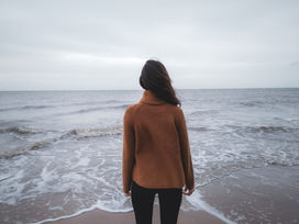 A woman looking out to sea, representing feeling anxious even though she knows nothing is wrong.