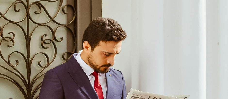 Haber metnini okuyan takım elbiseli kişi