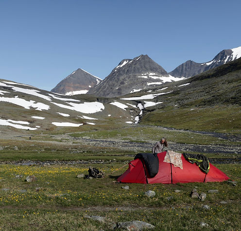 zelt rot in der Gebirgslandschaft mit bergen die schneebedeckt sind